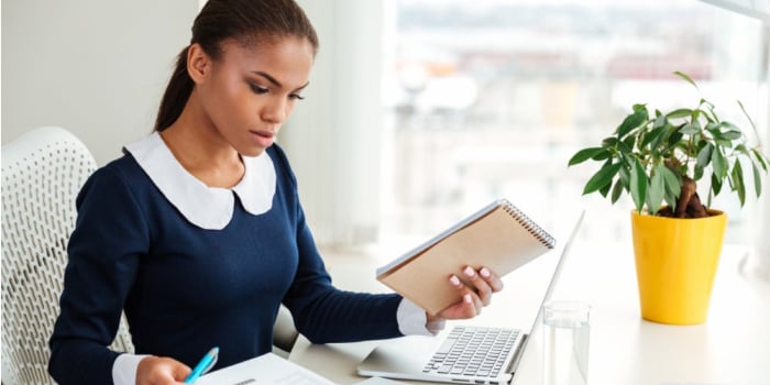 20170731105550-graphicstock-african-business-woman-in-dress-working-with-laptop-and-documents-on-workplac